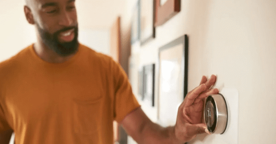 man operating smart thermostat