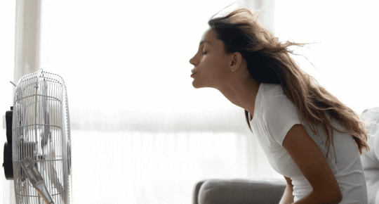 woman cooling with fan