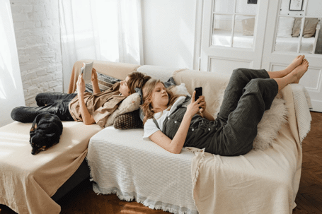 teenage kids laying on couch