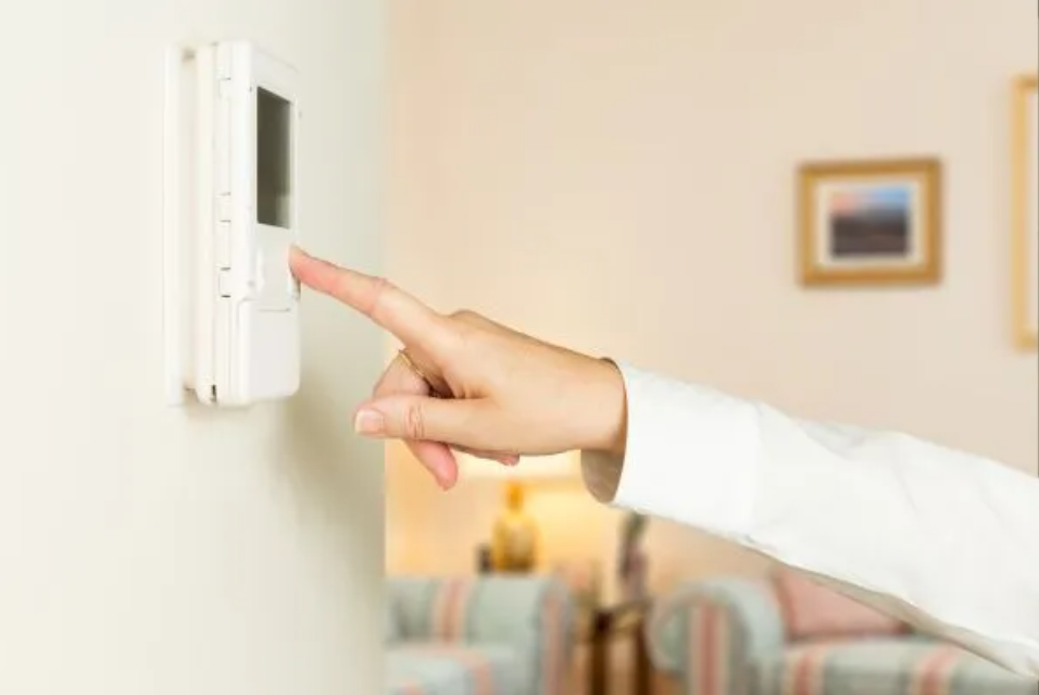 woman operating thermostat