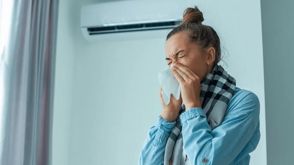 young woman sneezing into tissue